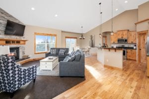 Open floor plan of Living Room and Kitchen with Fireplace and distinctive wood trim and cabinets in a new home construction of a single family home in Billings MT, a Safe and Secure kid friendly neighborhood.